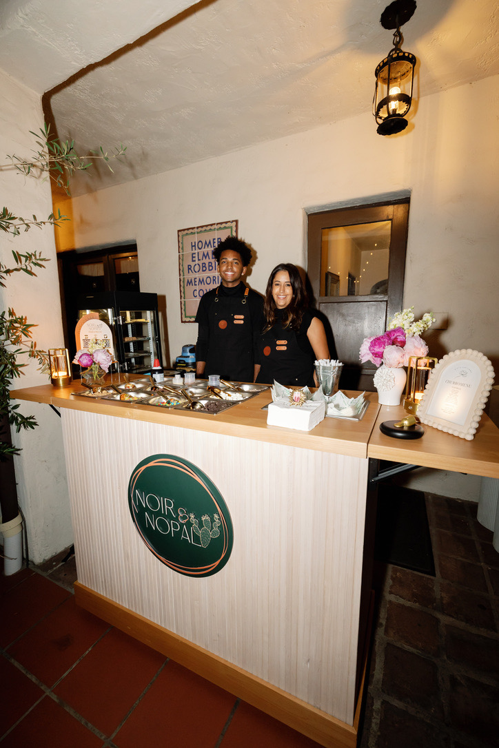 The Luxe Churro Cart styled and stocked indoors, with two staff members behind it